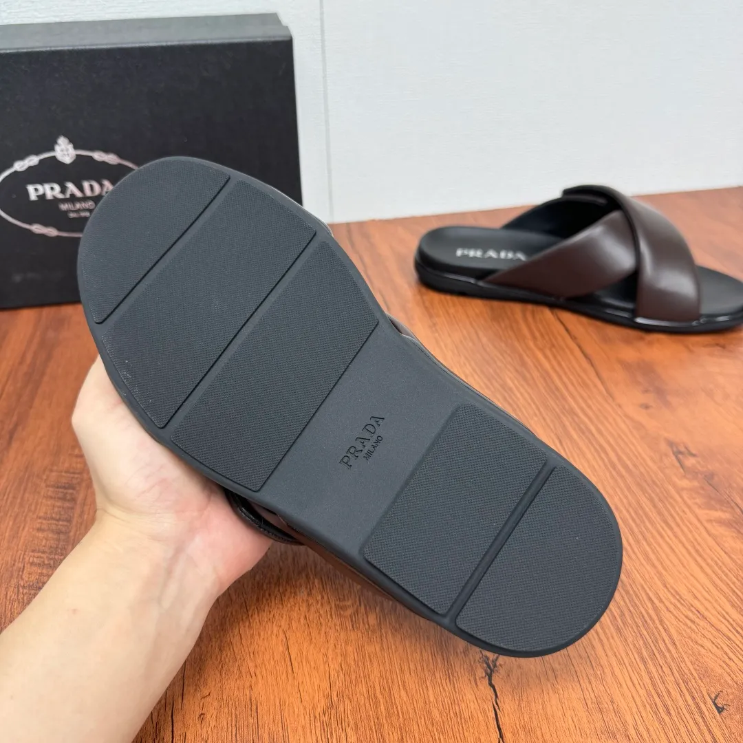 Batch 580 Prada/Prada's new men's leather cross slippers. Velcro closure can finely adjust the size. Calf leather light luxury slippers. Thick soft calf leather wraps the upper. Fat but soft rubber lazy style, soft and comfortable, excellent foot feel. Genuine leather bottom layer, cross style, with a Velcro closure buckle, easy to adjust the appropriate size, and a perfect fit for the wearing experience. The enamel gold triangle logo highlights the brand's classic features. Lightweight rubber thin sole, high foot comfort! Complete package! Size: 39-40-41-42-43-44-45 Leather shoe size Item number: 2X7132 Brown
